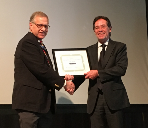 two men shake hands during an award presentation