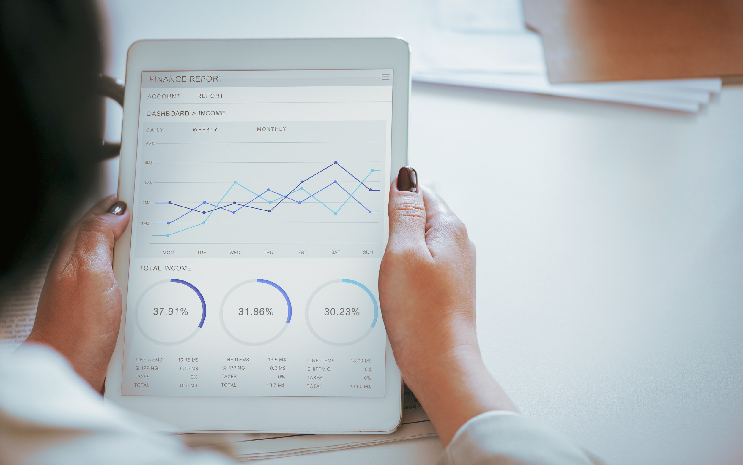 woman holds tablet, looking at a financial report