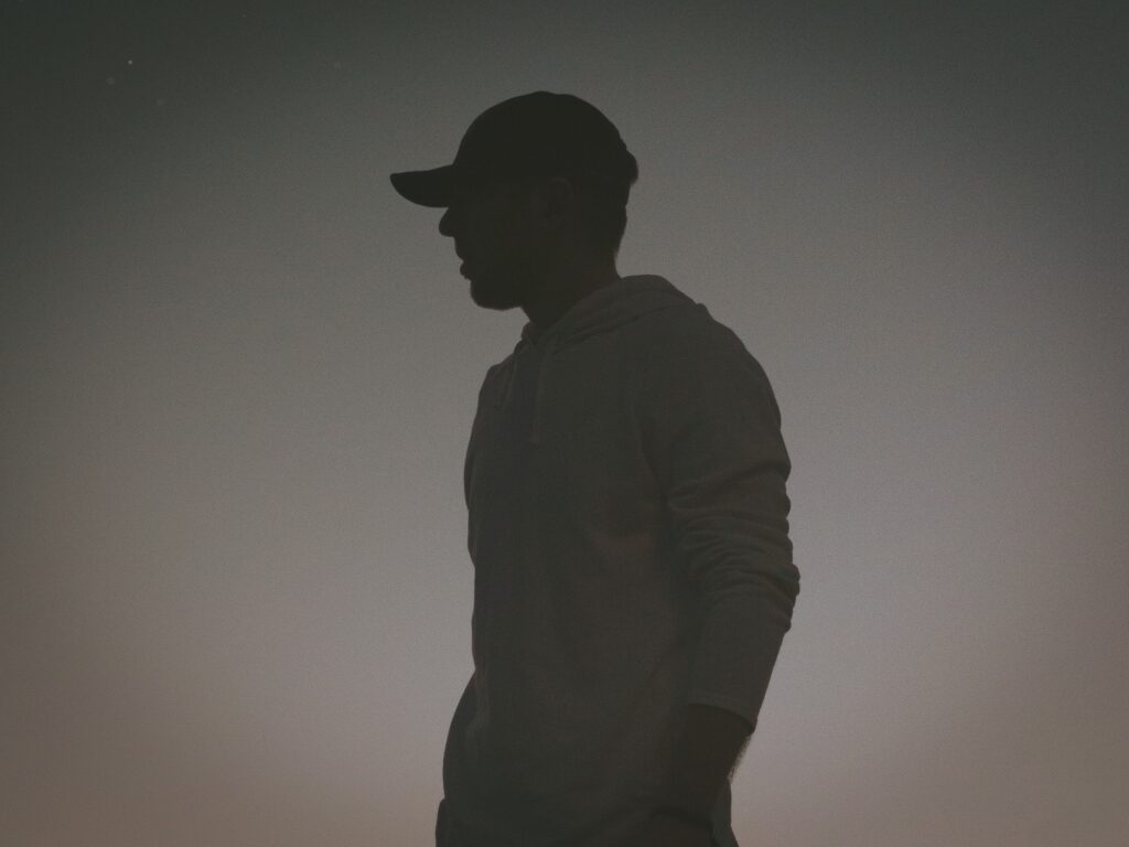 silhouette profile of a man in a baseball cap