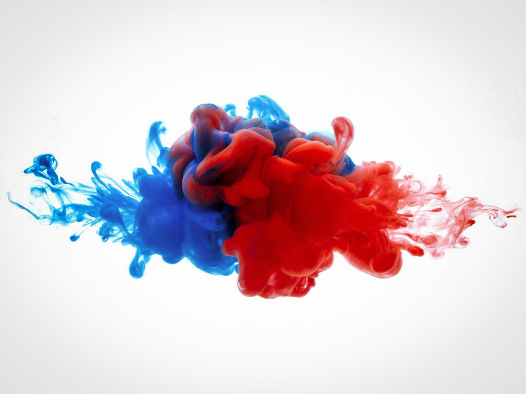 Blue and red ink blobs swirl and mix suspended in a vacuum