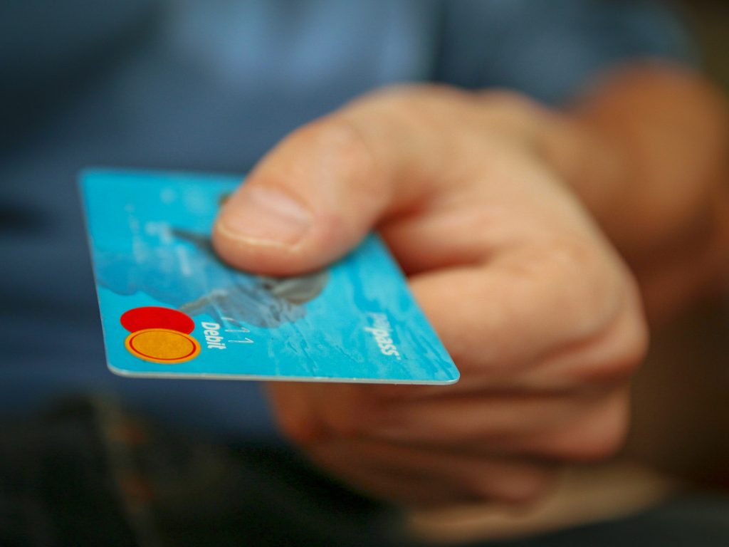 Close up of a hand holding a debit card